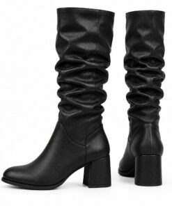 Pair of women's black vegan leather slouchy knee-high boots with block heel standing, side profile and back heel view