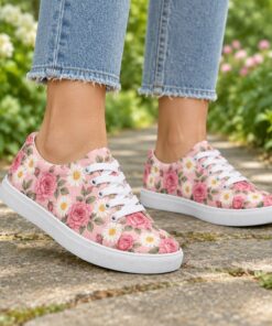 Woman wearing pink rose print low-top canvas sneakers on a sunny park path, cropped from the knees down